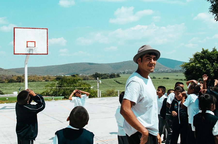 Saul Flores standing with elementary school students in Atencingo, Mexico.